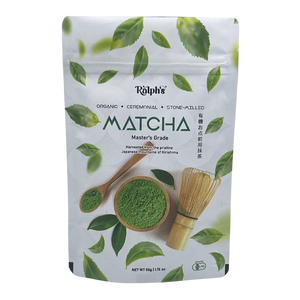 Ralph's organic ceremonial matcha powder pouch with spoon, whisk, and green tea leaves