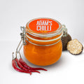 Jar of Adam's Chilli sauce with fresh red chili peppers and black truffle, plant-based food UAE