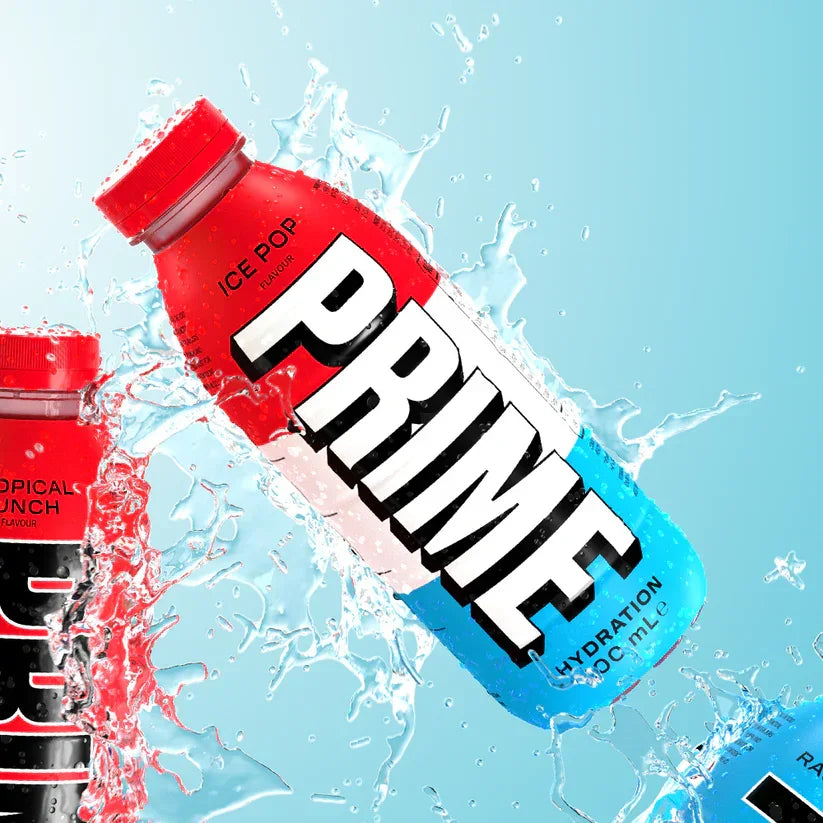 Red, white, and blue Prime hydration drink bottle with ice pop flavor, water splash background