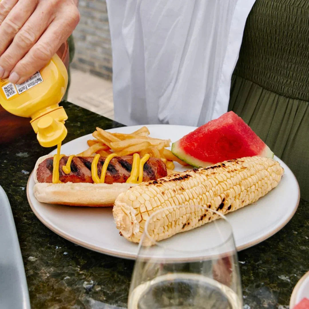 Plate with plant-based hot dog, grilled corn, fries, and watermelon at iPlantBased UAE